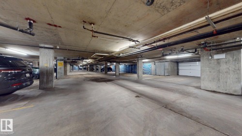 Underground parking garage featuring concrete flooring and structural columns - 405 16303 95 Street Nw, Edmonton, AB - Indoor Photo Showing Garage