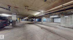 Underground parking garage featuring concrete flooring and structural columns - 