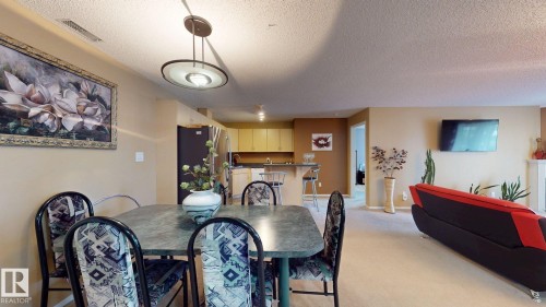 Dining area featuring a contemporary pendant light fixture - 405 16303 95 Street Nw, Edmonton, AB - Indoor Photo Showing Dining Room