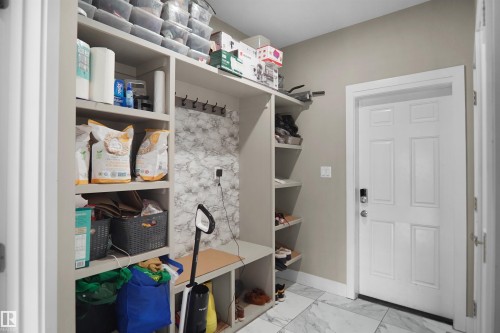 Built-in mudroom-style shelving unit with a bench, coat hooks, and integrated storage cubbies - 6108 173 Ave, Edmonton, AB 