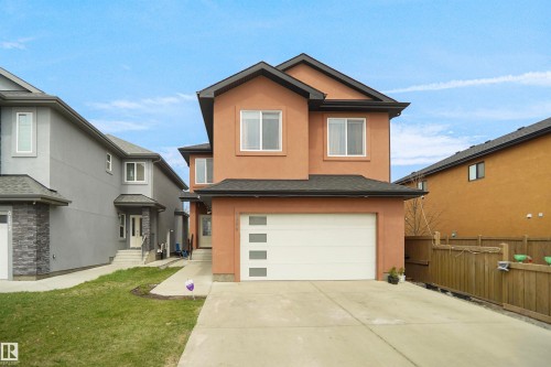Contemporary two-story residence featuring a two-car garage with a modern door, a concrete driveway, and a stucco exterior finish - 6108 173 Ave, Edmonton, AB 