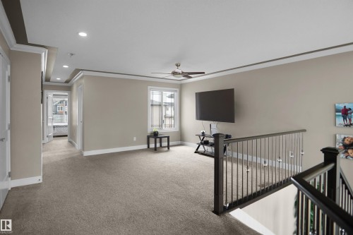 Upper-level landing featuring neutral carpeting, a tray ceiling with recessed lighting, and a modern ceiling fan - 6108 173 Ave, Edmonton, AB 
