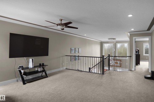 Carpeted upper-level space featuring a contemporary ceiling fan, recessed lighting, and crown molding - 6108 173 Ave, Edmonton, AB 