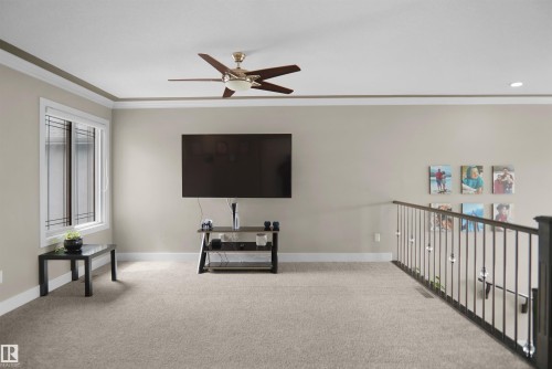 Carpeted upper-level space featuring a contemporary ceiling fan, recessed lighting, and a white-framed window with integrated grilles - 6108 173 Ave, Edmonton, AB 