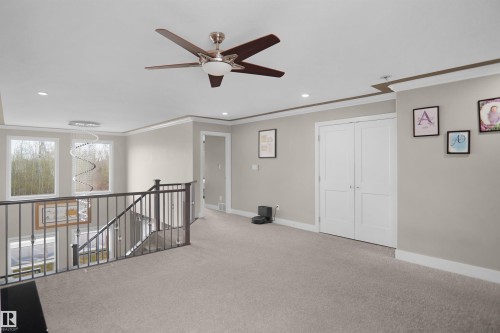 Carpeted loft area featuring a ceiling fan with light, recessed lighting, and crown molding - 6108 173 Ave, Edmonton, AB 