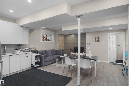 Open-concept living area featuring wood-finish flooring, recessed lighting, and a window with horizontal blinds - 6108 173 Ave, Edmonton, AB 