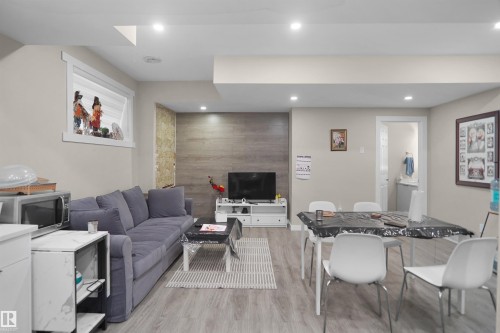 Open-concept living space featuring recessed lighting, light wood-finish flooring, and a window with white trim - 6108 173 Ave, Edmonton, AB 