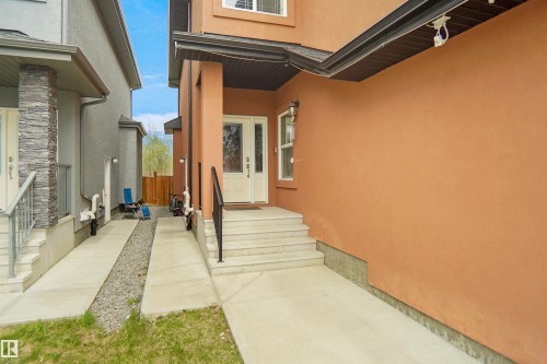 Stucco exterior with a contrasting soffit, white framed window, and a white front entry door with decorative glass inserts - 6108 173 Ave, Edmonton, AB 