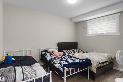 Room featuring neutral wall paint, a ceiling-mounted light fixture, and wood-finish flooring - 6108 173 Ave, Edmonton, AB 