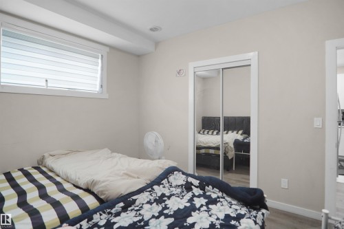 Bedroom featuring a window with horizontal blinds, overhead recessed lighting, and a mirrored sliding closet door - 6108 173 Ave, Edmonton, AB 