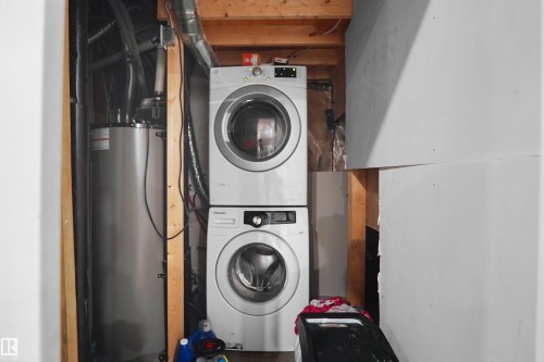 Dedicated utility space featuring a stacked washer and dryer - 6108 173 Ave, Edmonton, AB 
