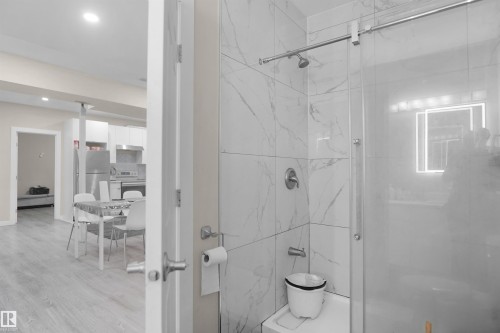 Modern bathroom featuring a tiled shower with a sliding glass door and contemporary fixtures - 6108 173 Ave, Edmonton, AB 