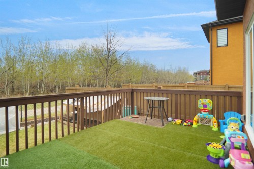 Rear deck featuring artificial turf and a wooden railing - 6108 173 Ave, Edmonton, AB 
