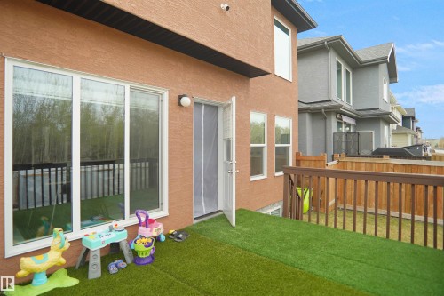 Exterior patio with artificial turf, featuring a wood railing and privacy fencing - 6108 173 Ave, Edmonton, AB 