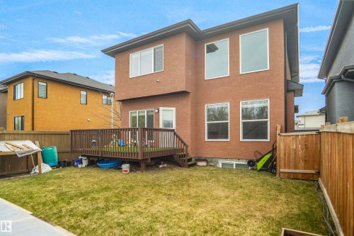 Rear exterior featuring a wood deck, sliding glass door, and multiple windows - 6108 173 Ave, Edmonton, AB 