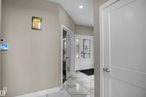 Entryway featuring large format tiled flooring, a modern front door with decorative glass inserts, and a recessed ceiling light - 6108 173 Ave, Edmonton, AB 