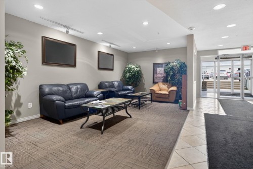The property features a reception area with recessed lighting, track lighting, and a combination of carpet and tile flooring - 423 2430 Guardian Road, Edmonton, AB - Indoor