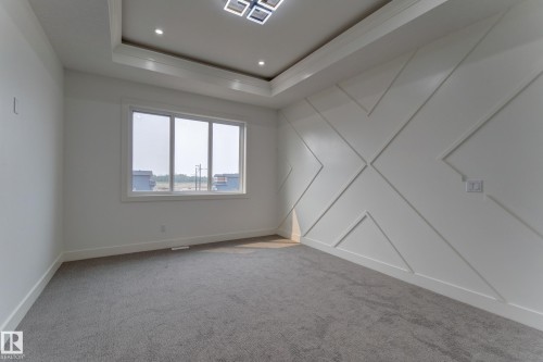 Recessed lighting illuminates a coffered ceiling with a modern flush-mount fixture - 4727 17 Avenue, Edmonton, AB 