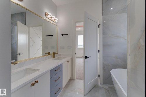 Double vanity featuring dual sinks, white countertops, and gold-tone fixtures - 4727 17 Avenue, Edmonton, AB 