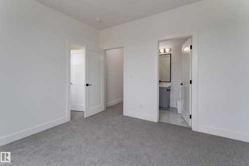 Bedroom featuring gray carpeting, white walls, and white trim - 4727 17 Avenue, Edmonton, AB 