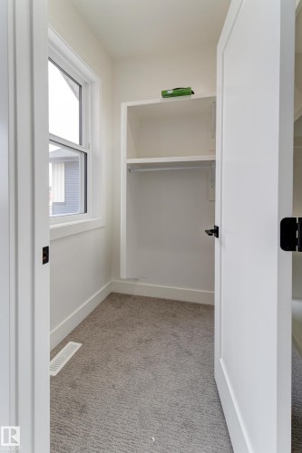 Bright closet space featuring a single-hung window, built-in shelving, and a hanging rod - 4727 17 Avenue, Edmonton, AB 