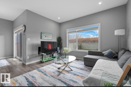 Living area with wood-finish flooring, recessed lighting, and a large window - 243 39 Avenue Nw, Edmonton, AB - Indoor Photo Showing Living Room