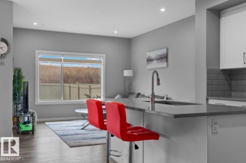 Kitchen island with an undermount sink and a gooseneck faucet - 243 39 Avenue Nw, Edmonton, AB - Indoor