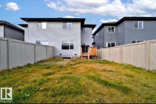 Fully fenced backyard featuring a wooden deck with stairs and a sliding glass door entry to the property - 243 39 Avenue Nw, Edmonton, AB - Outdoor With Exterior