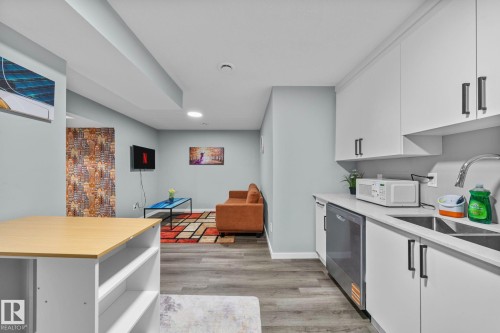 Integrated living area with wood-finish flooring - 243 39 Avenue Nw, Edmonton, AB - Indoor Photo Showing Other Room
