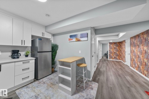 Kitchenette with white shaker cabinetry, stainless steel refrigerator, and light countertops - 243 39 Avenue Nw, Edmonton, AB - Indoor Photo Showing Kitchen