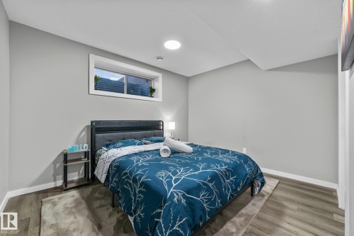Bedroom featuring a rectangular window with a deep sill, wood-finish flooring, and recessed ceiling lighting - 243 39 Avenue Nw, Edmonton, AB - Indoor Photo Showing Bedroom