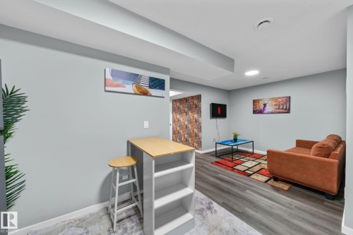 Open concept living space featuring light gray walls, wood-finish flooring, and recessed lighting - 243 39 Avenue Nw, Edmonton, AB - Indoor Photo Showing Basement