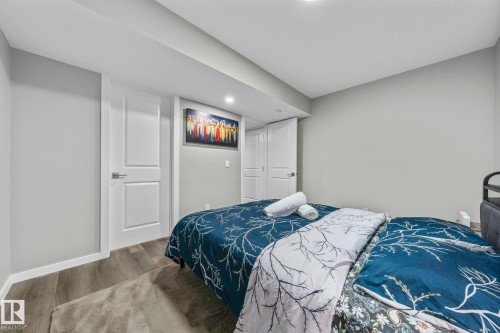 Spacious room featuring light gray walls, white trim, wood-finish flooring, and recessed ceiling lighting - 243 39 Avenue Nw, Edmonton, AB - Indoor Photo Showing Bedroom
