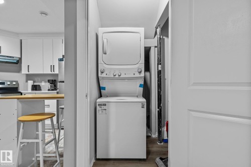 Compact laundry area featuring a stacked washer and dryer - 243 39 Avenue Nw, Edmonton, AB - Indoor Photo Showing Laundry Room