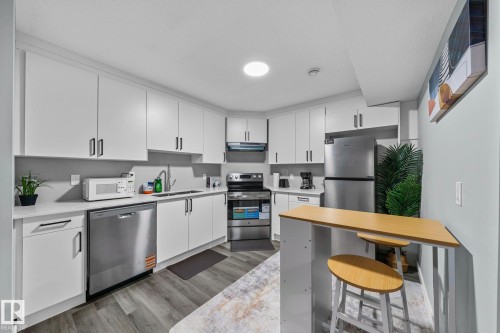 Modern kitchen with white cabinetry and light-toned countertops - 243 39 Avenue Nw, Edmonton, AB - Indoor Photo Showing Kitchen With Stainless Steel Kitchen