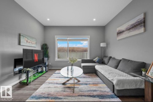 Living space featuring wood-finish flooring, recessed lighting, and a large window - 243 39 Avenue Nw, Edmonton, AB - Indoor Photo Showing Living Room