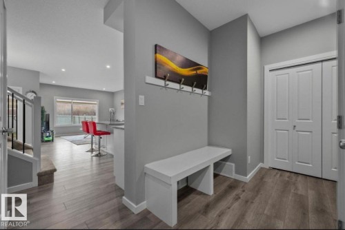 Entryway featuring wood-finish flooring, a built-in bench, and a coat rack - 243 39 Avenue Nw, Edmonton, AB - Indoor Photo Showing Other Room