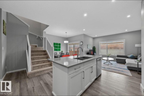 Open-concept living space with wood-finish flooring - 243 39 Avenue Nw, Edmonton, AB - Indoor Photo Showing Kitchen With Double Sink