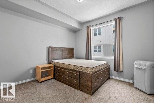 Carpeted room with a single window, light gray wall color, and white trim - 304 10011 110 Street, Edmonton, AB - Indoor Photo Showing Bedroom
