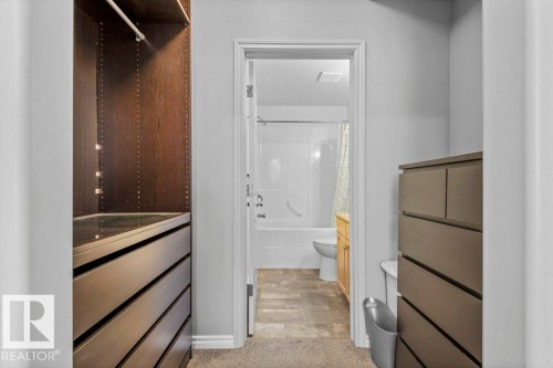 Custom closet system featuring dark wood-finish shelving and integrated drawer units - 304 10011 110 Street, Edmonton, AB - Indoor Photo Showing Bathroom