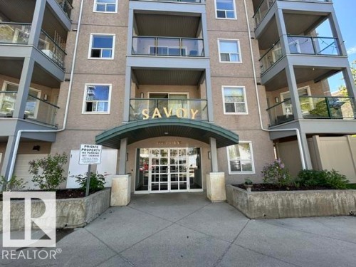 Multi-story residential building featuring a stucco facade and glass-paneled balconies - 304 10011 110 Street, Edmonton, AB - Outdoor