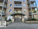 Multi-story residential building featuring a stucco facade and glass-paneled balconies - 304 10011 110 Street, Edmonton, AB  - Outdoor 