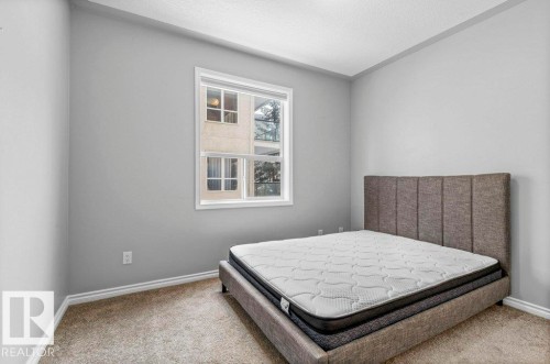 Light gray wall paint complemented by white trim and a neutral carpet - 304 10011 110 Street, Edmonton, AB - Indoor Photo Showing Bedroom