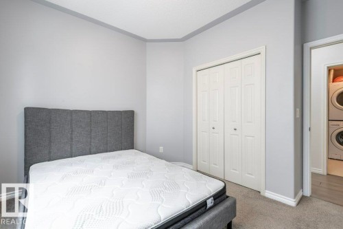 Bedroom space with light gray walls, white trim, and gray carpeted flooring - 304 10011 110 Street, Edmonton, AB - Indoor