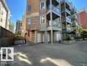 Multi-story building exterior featuring a textured facade, multiple glass-paneled balconies, and a covered main entrance - 304 10011 110 Street, Edmonton, AB  - Outdoor 