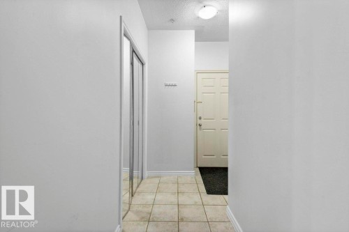 Entryway featuring tile flooring and mirrored closet doors - 304 10011 110 Street, Edmonton, AB - Indoor Photo Showing Other Room