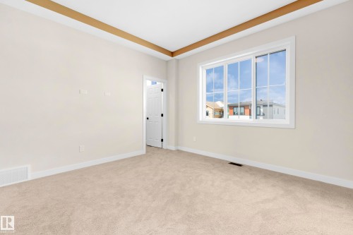 Neutral-toned wall-to-wall carpeting complements light beige walls - 4915 17 Avenue, Edmonton, AB - Indoor Photo Showing Other Room
