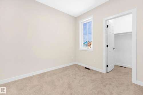 Carpeted interior room featuring light neutral wall paint, white trim, a single window, and a closet with a white door - 4915 17 Avenue, Edmonton, AB - Indoor Photo Showing Other Room