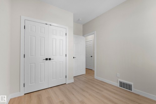 Interior room featuring neutral wall paint, light wood-finish flooring, and white baseboards - 4915 17 Avenue, Edmonton, AB - Indoor Photo Showing Other Room
