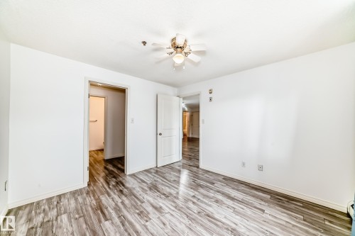 Spacious interior room featuring wood-finish flooring, bright white walls, and a ceiling fan - 210 2305 35A Avenue, Edmonton, AB - Indoor Photo Showing Other Room
